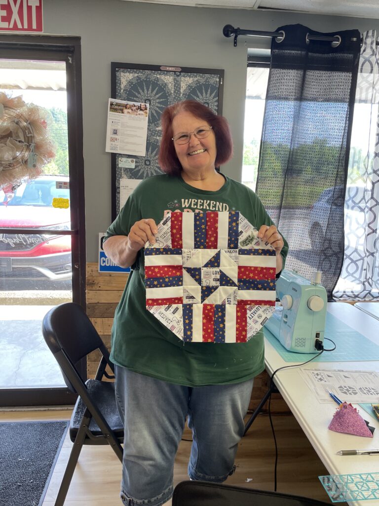 Debbie Crabtree holding a red, white, and blue place mat.